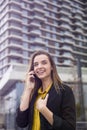 Young business woman uses cellphone at the street against office building Royalty Free Stock Photo