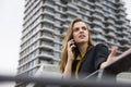 Young business woman uses cellphone at the street against office building Royalty Free Stock Photo