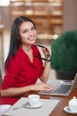 Young business woman uses laptop in cafe Royalty Free Stock Photo