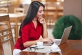 Young business woman uses laptop in cafe Royalty Free Stock Photo