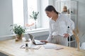 Young business woman uses laptop. Stands at desktop in office.