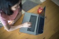 Young business woman using laptop computer working on wooden table with copy space. Asian girl typing on notebook in coffee shop,