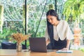 Young business woman using laptop with document report at cafe. Royalty Free Stock Photo