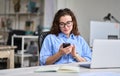 Young business woman using mobile phone working in office sitting at desk. Royalty Free Stock Photo