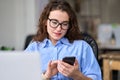 Young business woman using mobile phone working in office sitting at desk. Royalty Free Stock Photo