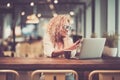 Young business woman in video conference call with phone and laptop computer sit down at bar cafe in the airport waiting to flight Royalty Free Stock Photo