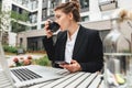 Young business woman wearing glasses at cafe using laptop and drinking coffee Royalty Free Stock Photo