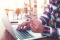 young business woman working on her laptop and using credit card sitting at wooden table in a coffee shop Royalty Free Stock Photo