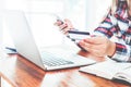 Young business woman working on her laptop and using credit card sitting at wooden table Royalty Free Stock Photo