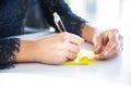 Young business woman is working, writing on the paper or notepad and meeting with the co-worker in the office about the future of Royalty Free Stock Photo