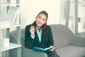 Young businesslady making notes in note book at workplace in the office. Secretary woman in formal wear working on Royalty Free Stock Photo