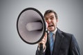 Young businessman is announcing a message and shouting to megaphone