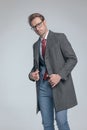 Young businessman arranging his coat, wearing eyeglasses Royalty Free Stock Photo