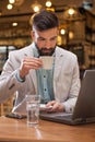 Young businessman with beard in cafe on coffee break Royalty Free Stock Photo