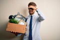 Young businessman with beard fired holding cardboard standing over white background stressed with hand on head, shocked with shame Royalty Free Stock Photo