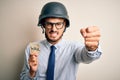 Young businessman with beard wearing helmet holding paper with war message annoyed and frustrated shouting with anger, crazy and