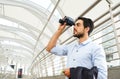 Young businessman with binoculars looking for opportunity to develop business in the future