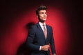 Young businessman in black with red tie arranging his jacket