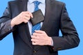 A young businessman in a blue shirt and tie hides a man& x27;s wallet in the inside pocket of his jacket Royalty Free Stock Photo