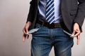 A young businessman in a business suit showing his empty pockets. Financial difficulties, bad economy, no money concept Royalty Free Stock Photo