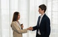 Young businessman and businesswoman shake hand together, smile, hold tablet, standing, wear suit. Young man and woman work Royalty Free Stock Photo