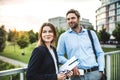 A young businessman and businesswoman standing on a bridge. Royalty Free Stock Photo