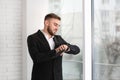 Young businessman checking time near window Royalty Free Stock Photo