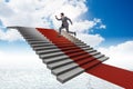 The young businessman climbing stairs and red carpet into sky Royalty Free Stock Photo