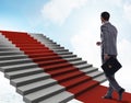 Young businessman climbing stairs and red carpet into sky Royalty Free Stock Photo