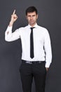 Young businessman criticizing on gray background Royalty Free Stock Photo