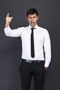Young businessman criticizing on gray background Royalty Free Stock Photo