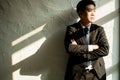 Young businessman with crossed arms standing near the office window, business concept