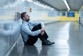 Young businessman crying abandoned lost in depression sitting on ground subway Royalty Free Stock Photo