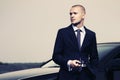 Young businessman in dark blue suit next to his car Royalty Free Stock Photo