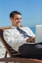 Young businessman on a deck chair using his computer Royalty Free Stock Photo