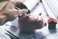 Young businessman depositing money in piggy bank Royalty Free Stock Photo