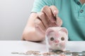 Young businessman depositing money in piggy bank Royalty Free Stock Photo