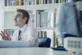 Young businessman discussing at a business meeting with colleague behind him