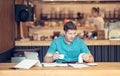 Young businessman doing books at a table during a late night in his restaurant. Young startup owner looking worried