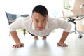 Young businessman doing exercises in office. Royalty Free Stock Photo