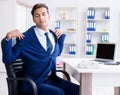 Young businessman doing sports stretching at workplace Royalty Free Stock Photo