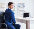 Young businessman doing sports stretching at workplace Royalty Free Stock Photo