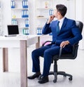 Young businessman doing sports stretching at workplace Royalty Free Stock Photo