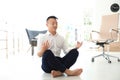 Young businessman doing yoga in office. Royalty Free Stock Photo