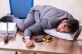 Young male employee in oversleeping concept Royalty Free Stock Photo