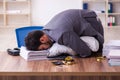 Young male employee in oversleeping concept Royalty Free Stock Photo