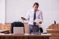 Young male employee stapling paper in the office Royalty Free Stock Photo