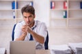 Young male employee and too much work in the office Royalty Free Stock Photo