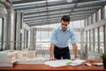 Young businessman, engineer working in office, working on plan or technical document. Royalty Free Stock Photo