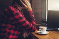 Young businessman enjoys coffee in the cafe talking on the phone and using a laptop